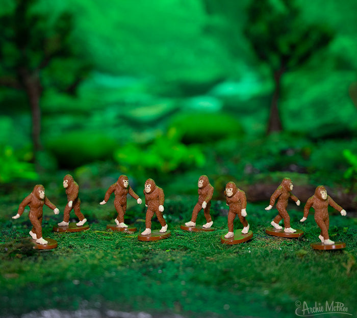 Among the vibrant greenery of the forest diorama, figures from the Itty Bitty Bigfoot collection roam, infusing a hint of fantasy into the scene.