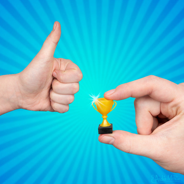 A hand holding an Itty Bitty Trophies product next to another giving a thumbs up, set against a blue radial background.