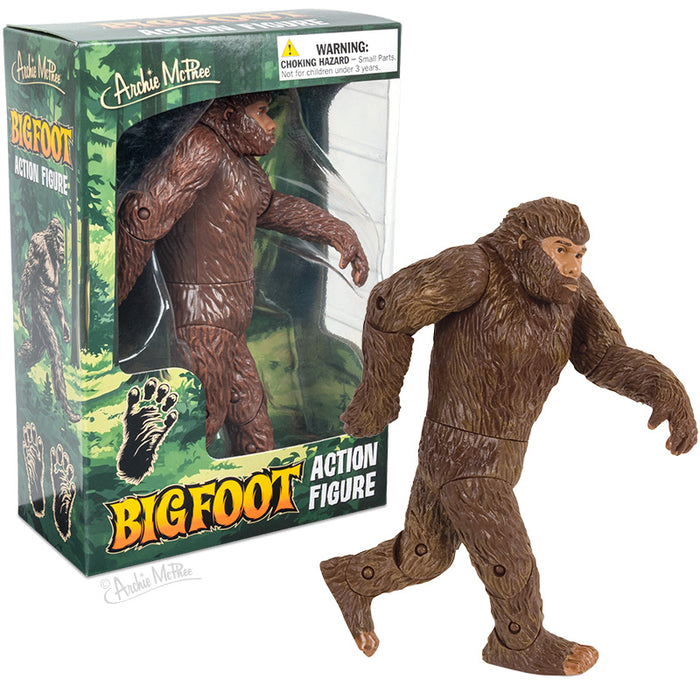 The Bigfoot Action Figure, an articulated vinyl toy inspired by the legendary Patterson film, is posed in front of its colorful, forest-themed box packaging.