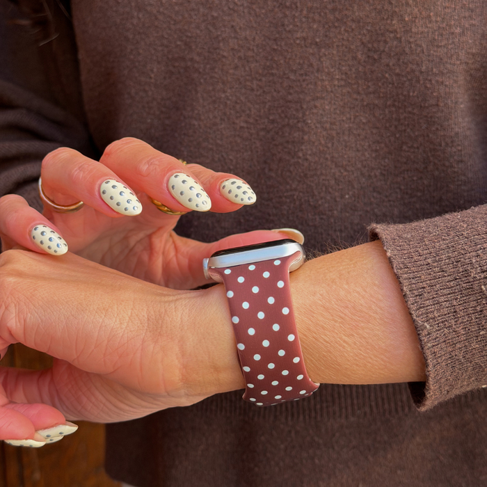 Girl wearing apple watch with the brown and blue polka dot watch strap