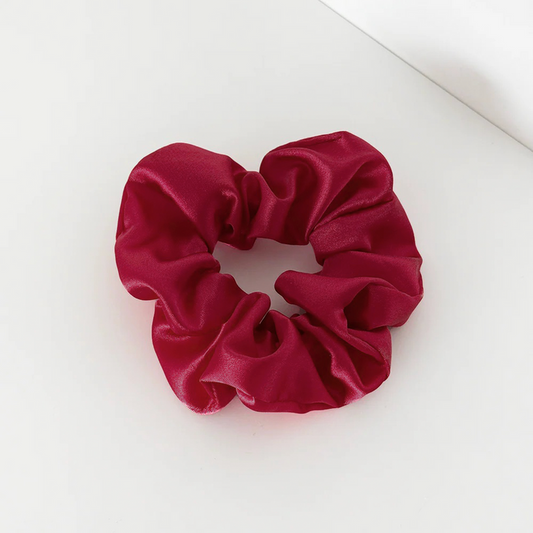 Burgundy satin scrunchie with a glossy finish shown on a white surface.