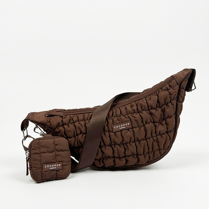 Espresso brown crescent crossbody dog walking bag with matching dispenser pouch against a white background.