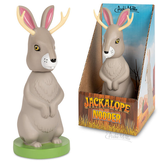 The Jackalope Nodder is a hard vinyl toy designed as a charming Jackalope character, encased in a Western-themed box. It includes an adhesive base for secure placement.