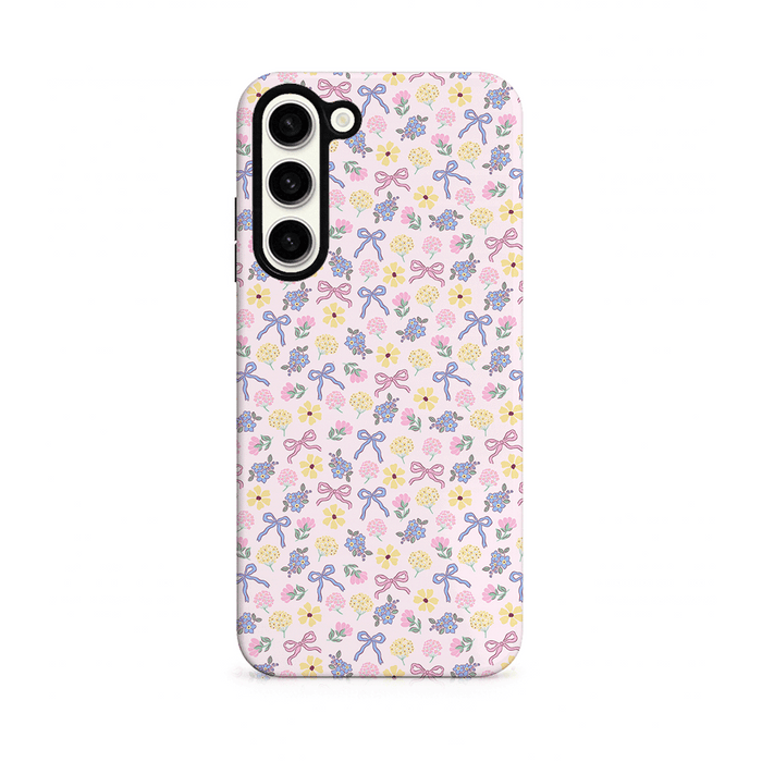 Phone case with floral and bow pattern on a pink background.