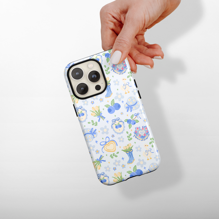 Phone case with floral pattern held by a hand on a light gray background