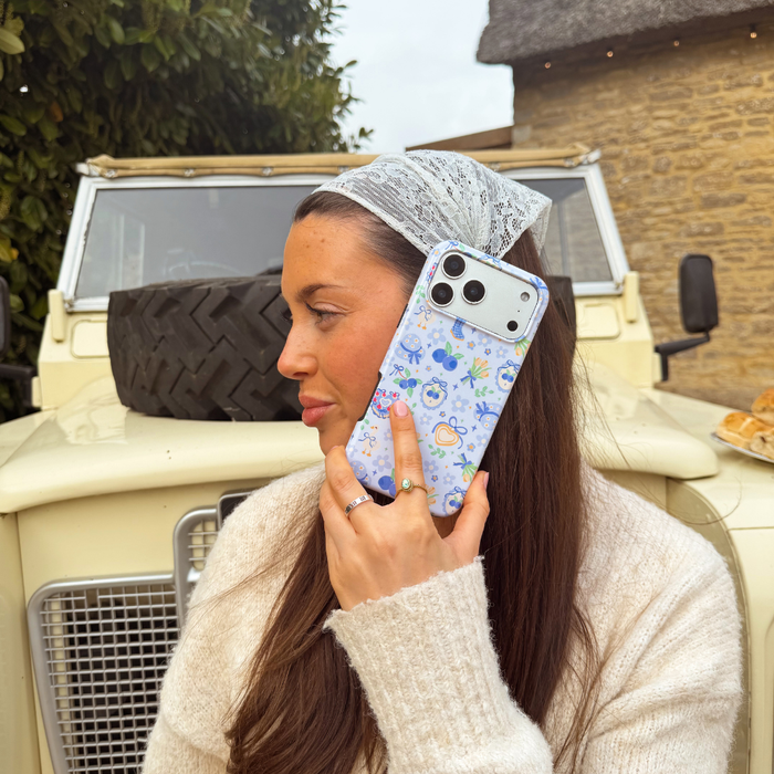 Girl holding blueberry picnic phone case to ear
