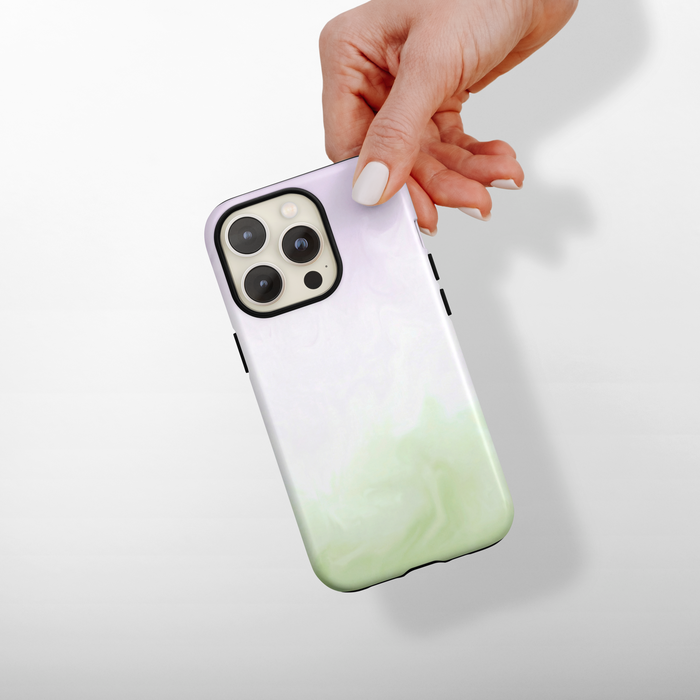 Phone case with matcha and lavender gradient design held by a hand on a light background