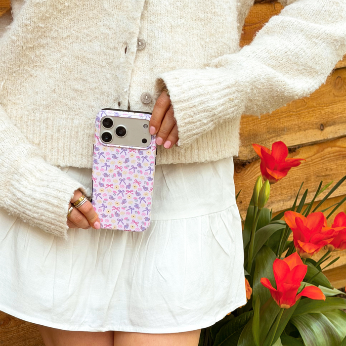 girl in cream cardigan next to flowers holding spring bows tough phone case