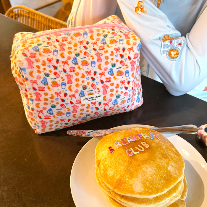 Coconut Lane Towel Makeup Bag - Breakfast Club with vibrant graphic print next to pancakes and a person’s arm.