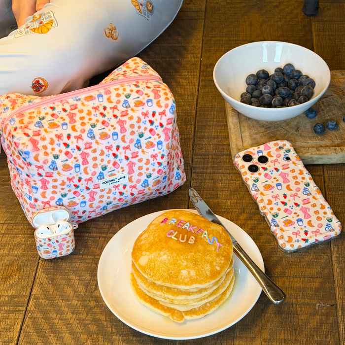 Coconut Lane Towel Makeup Bag with a Breakfast Club pancakes and blueberries print on a wooden table.